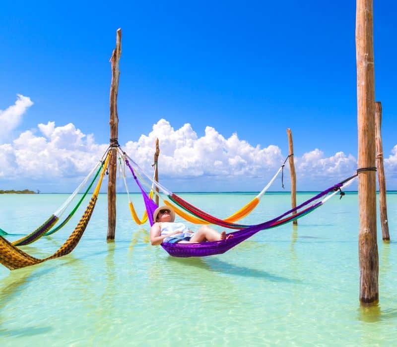 mujer, descansando en el mar caribe, en una hamaca en isla holbox  méxico