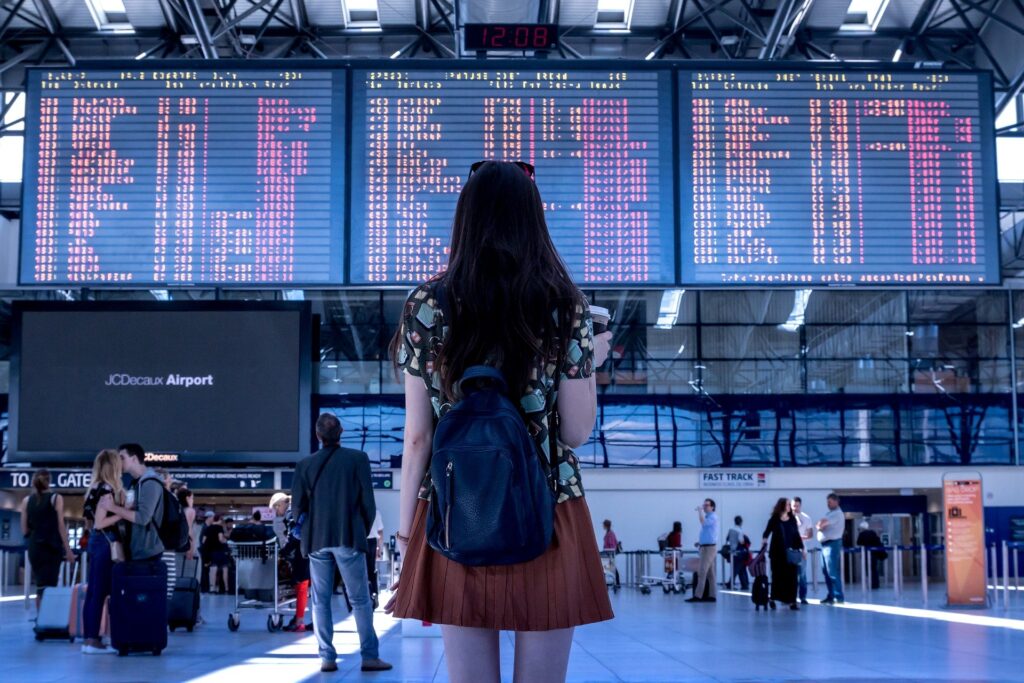 Chica viendo el tablero de salidas en el aeropuerto